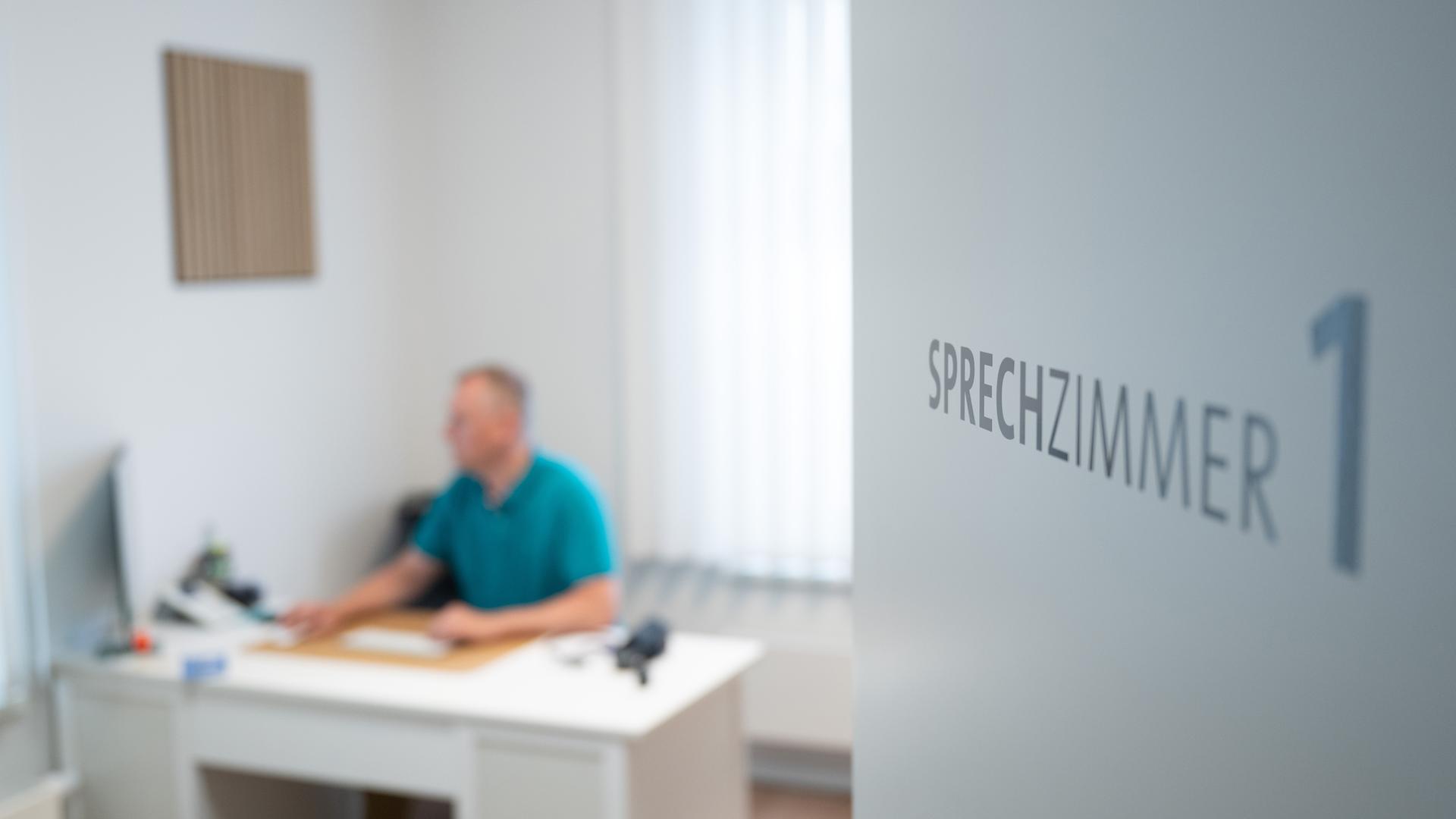 Ein Hausarzt in Dresden sitzt am 27.05.2025 in einem Sprechzimmer seiner Hausarztpraxis an einem Schreibtisch und arbeitet am Computer. 