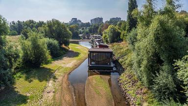Luftaufnahme von Hausbooten in einem Fluss mit Niedrigwasser.