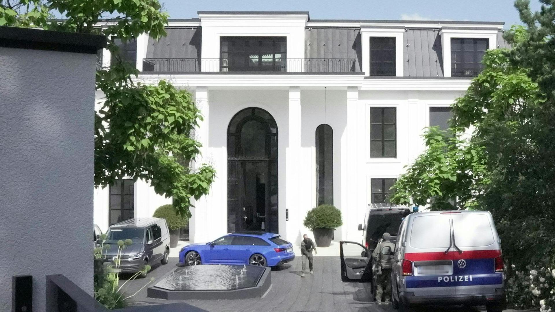 Österreich, Igls: Polizeiautos stehen während einer Hausdurchsuchung vor der Villa von René Benko im Innsbrucker Stadtteil Igls.