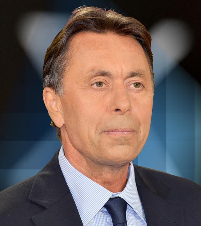 Autor Norbert Holz steht vor dem "X"- Logo
