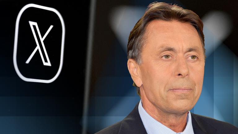 Autor Norbert Bolz steht vor dem "X"- Logo