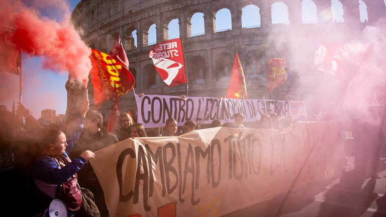 Teilnehmer einer Demonstration unter anderem gegen das Haushaltsgesetz der Regierung sind in Rom auf einer Straße unterwegs