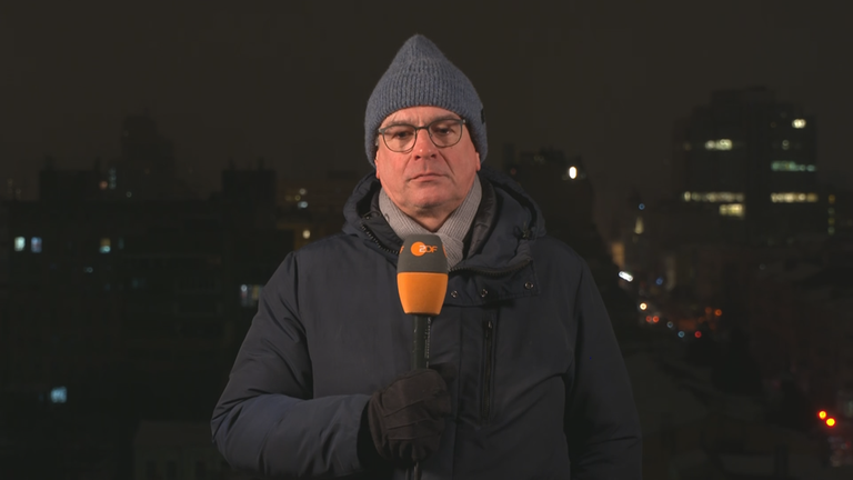 Henner Hebestreit mit Mikrofon, Mütze und Winterjacke