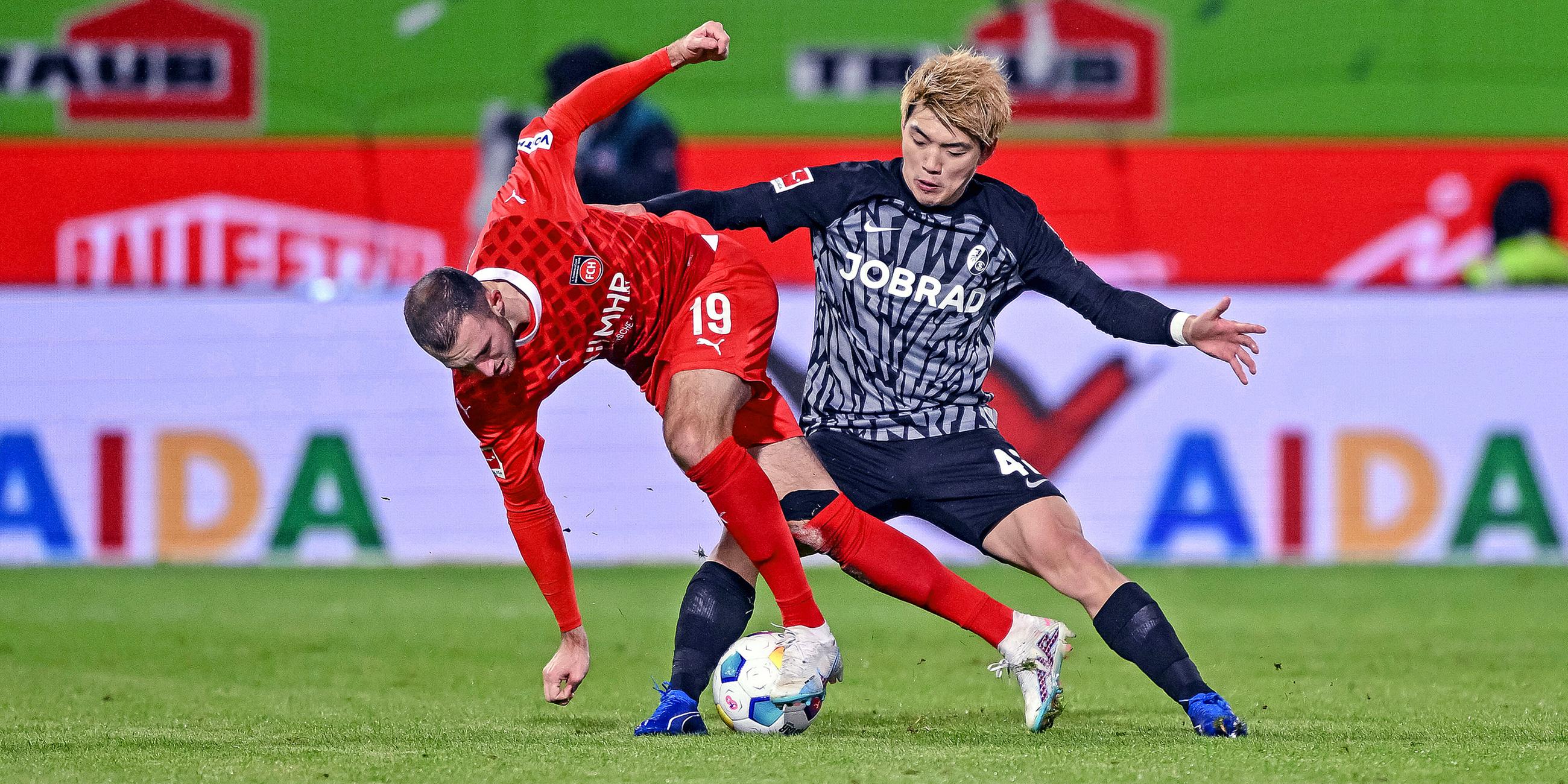 Heidenheims Jonas Foehrenbach (l) in Aktion gegen Freiburgs Ritsu Doan.