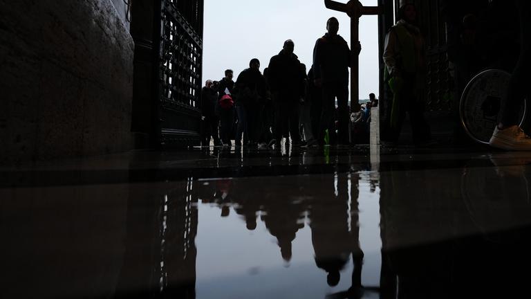 Pilger und Gläubige halten ein Kruzifix, als sie zum Petersdom im Vatikan kommen, um die Heilige Pforte am letzten Tag ihrer offiziellen Öffnung zu durchschreiten.