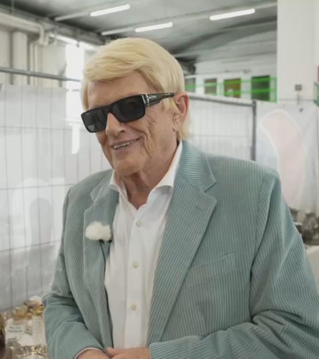 Das Bild zeigt Schlagersänger Heino in einer Lagerhalle mit den Gegenständen, die er versteigern wird.