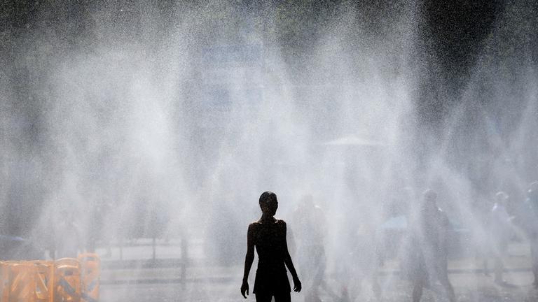 Passanten erfrischen sich an Wasserfontaenen, die von der Stadt Koeln im Rahmen der Hitzeaktion Cooling Cologne auf dem Rudolfplatz ausgelegt wurden.