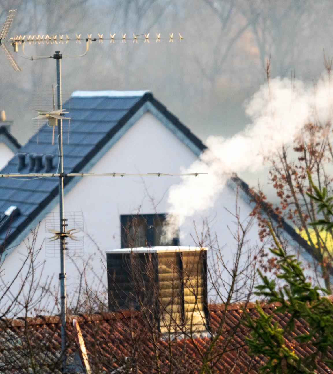 Rauch steigt aus mehreren Schornsteinen in einem Wohngebiet auft (Archivfoto)