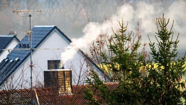 Rauch steigt aus mehreren Schornsteinen in einem Wohngebiet auft (Archivfoto)