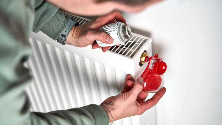 Mann entlüftet Heizung