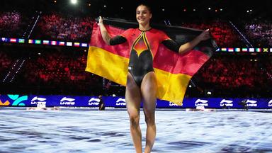 Helen Kevric aus Deutschland posiert mit der Nationalflagge nach dem Gewinn der Silbermedaille am Stufenbarren bei den Gerätefinals der Kunstturn-Weltmeisterschaften in Rotterdam, Niederlande.
