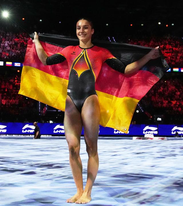 Helen Kevric aus Deutschland posiert mit der Nationalflagge nach dem Gewinn der Silbermedaille am Stufenbarren bei den Gerätefinals der Kunstturn-Weltmeisterschaften in Rotterdam, Niederlande.