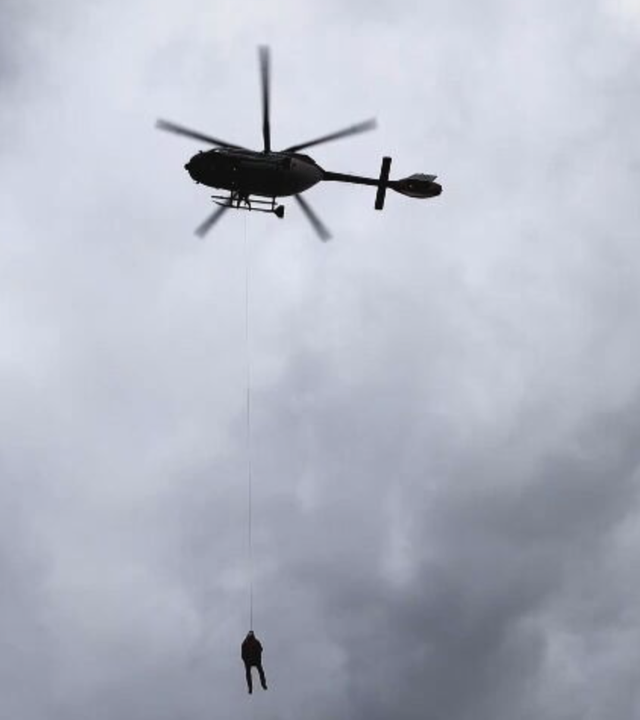 Helikopter rettet Person per Seilwinde vom Dach