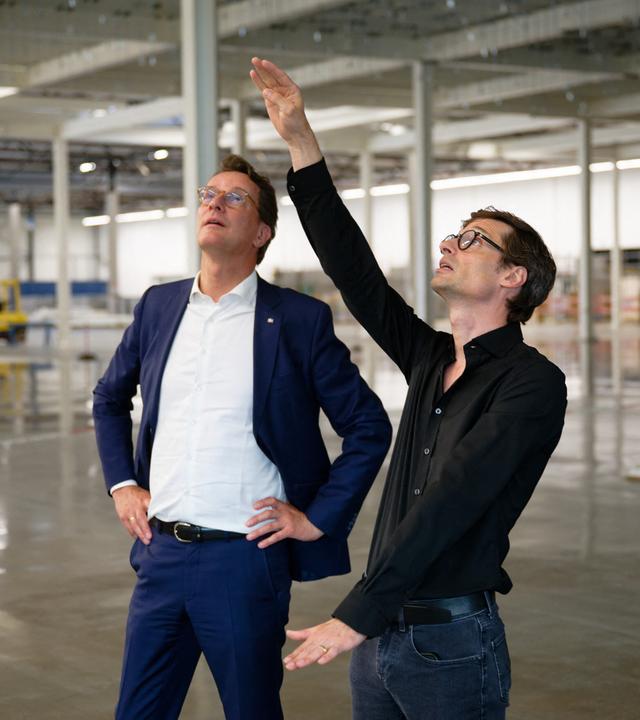 Der nordrhein-westfälische Ministerpräsident Hendrik Wüst (l, CDU) steht am 03.09.2026 im Rahmen seiner Sommertour mit dem CEO Daniel Schall bei einem Besuch der Chipfabrik von Black Semiconductor zum Start der neuen Bauphase in der zukünftigen Fabrik. 