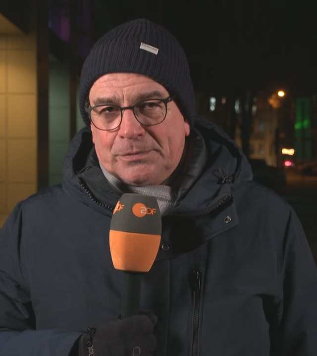ZDF-Reporter Henner Hebestreit aus der Ukraine mit ZDFR-Mikrofron in der Dunkelheit