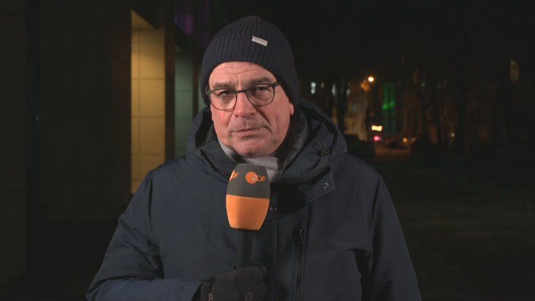 ZDF-Reporter Henner Hebestreit aus der Ukraine mit ZDFR-Mikrofron in der Dunkelheit