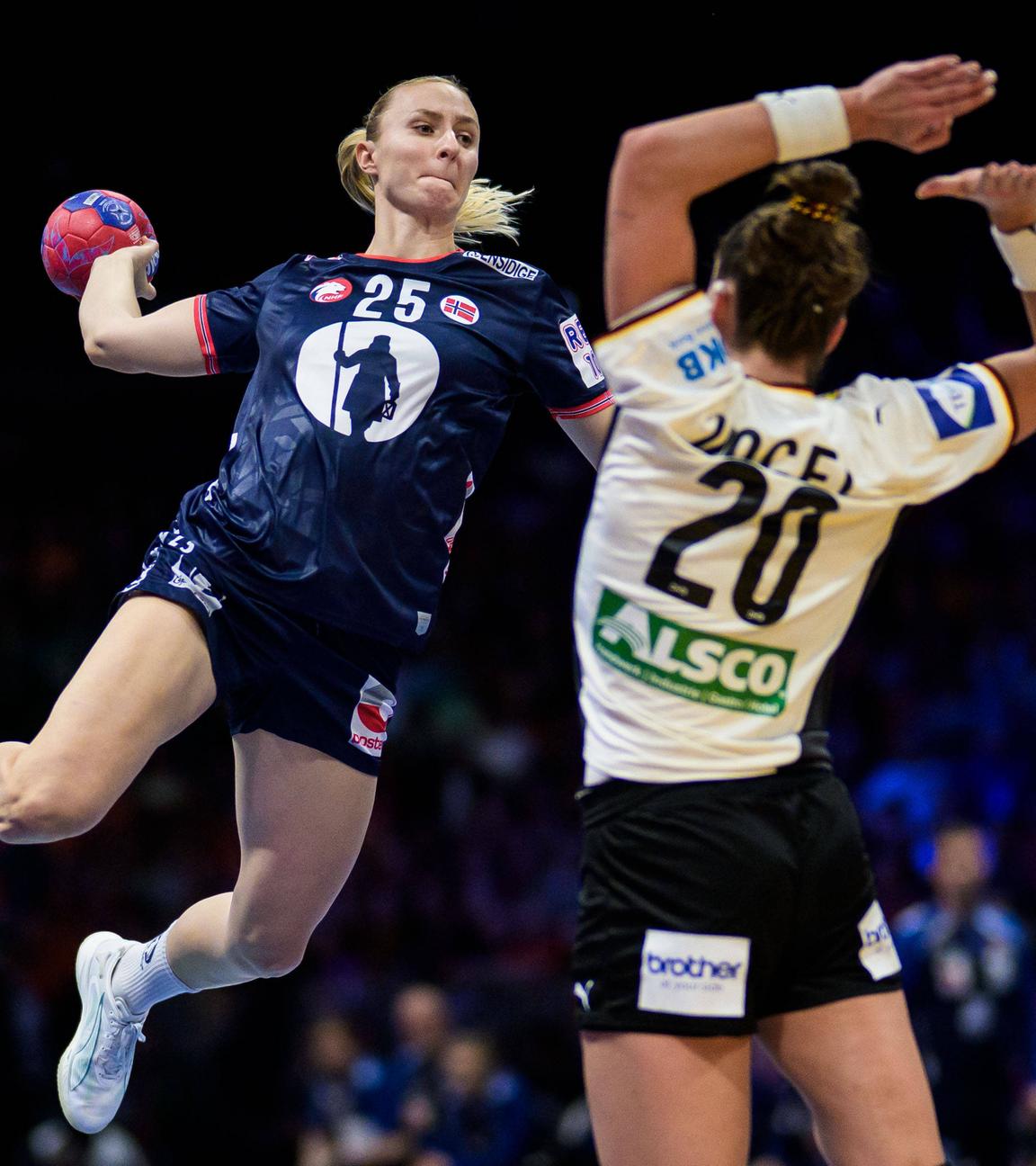 Norwegens Handballnationalspielerin Henny Ella Reistad setzt zum Wurf aus dem Sprung an um den Ball über die deutsche Nationalspielerin Emily Vogel zu werfen