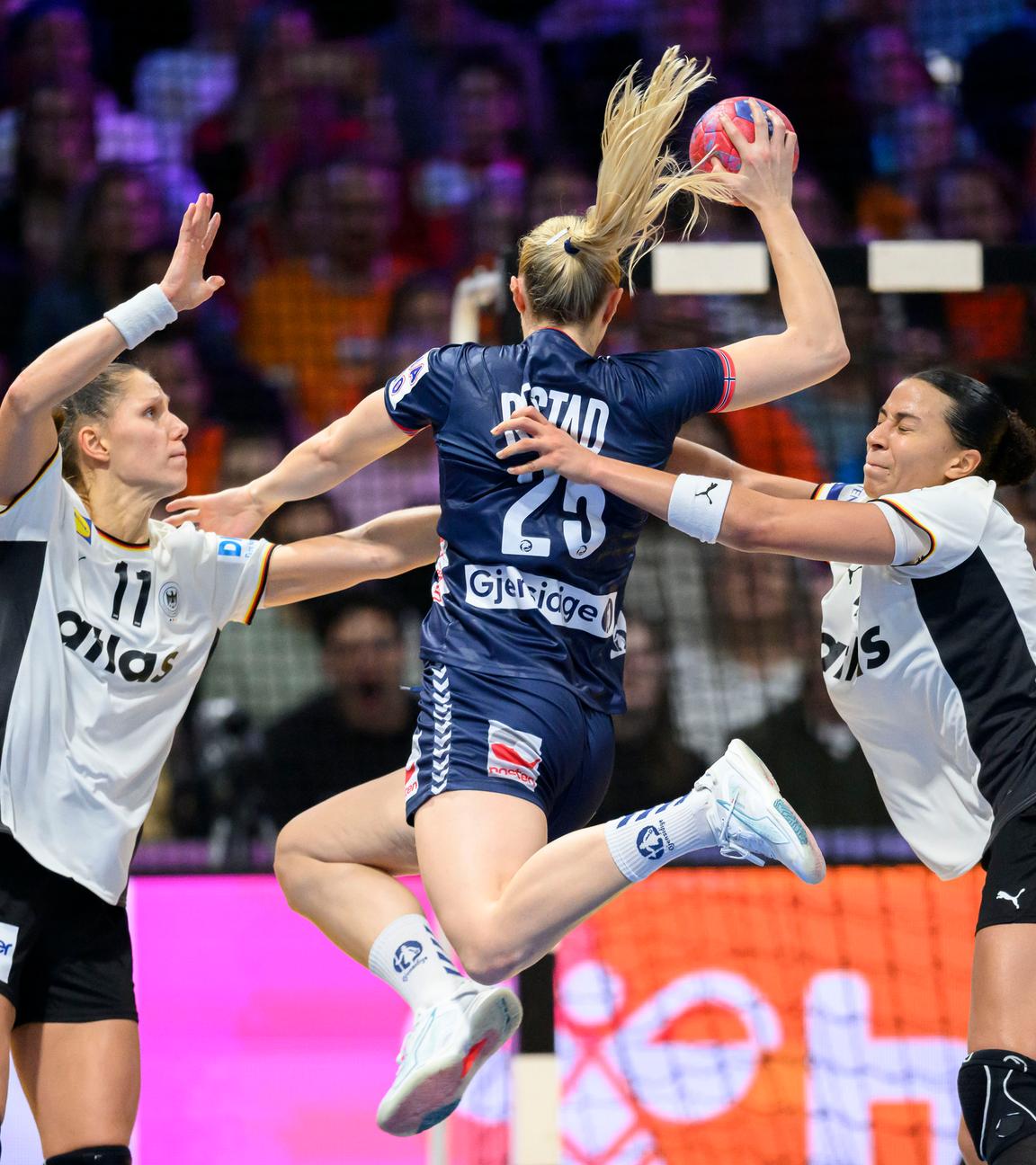 Norwegens Henny Ella Reistad setzt zum Wurf aus dem Sprung auf das deutsche Tor an, wird dabei aber von den deutschen Handballnationalspielerinnen Viola Leuchter und Aimée von Pereira behindert.