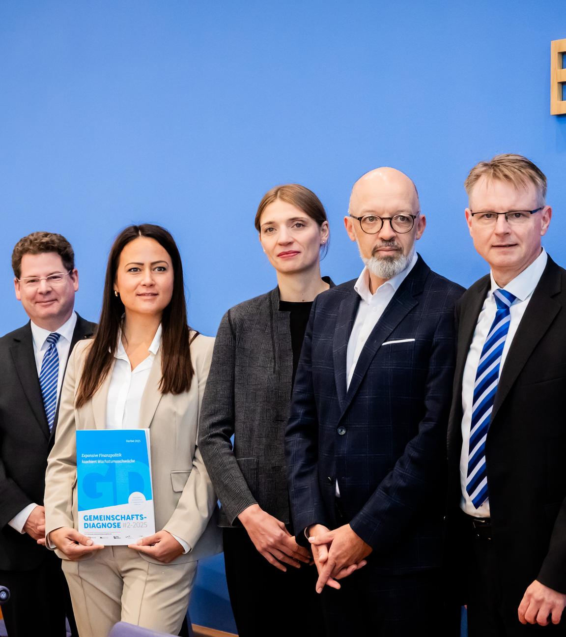 Mehrere Personen mit der Herbstprognose im Saal der Bundespressekonferenz.