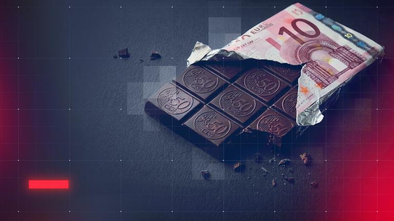 Eine Tafel Schokolade mit einer Umverpackung, auf der ein 10-Euro-Schein abgebildet ist. Die einzelnen Schokostücke tragen eine Prägung im Stil einer 50-Cent-Münze.