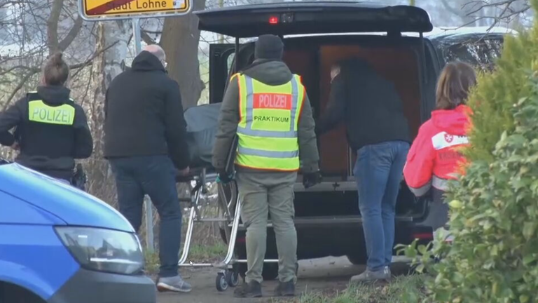 Polizeikräfte verstauen Leichnam eines 33-Jährigen im Kofferraum eines Leichenwagens am Tatort, Vechta