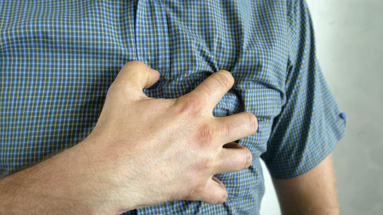 mann greift sich an die brust