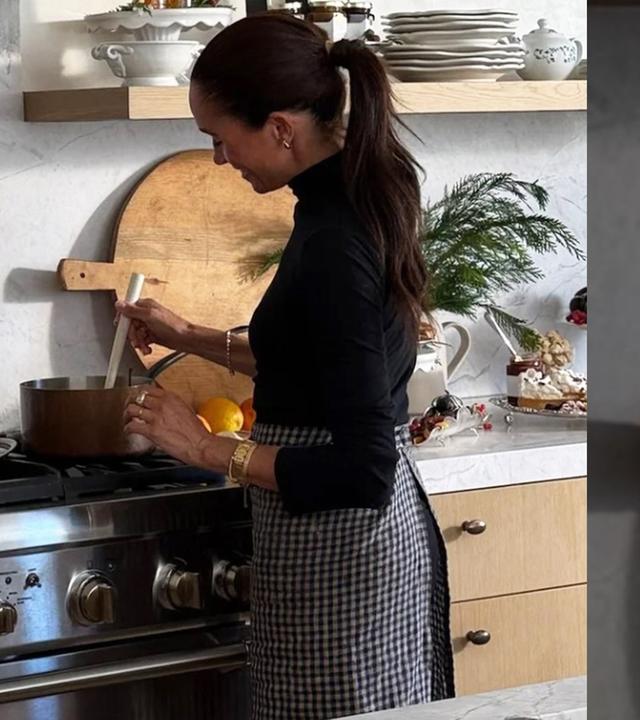 Herzogin Meghan rührt in einem Topf, der auf einem kalten Herd steht. 