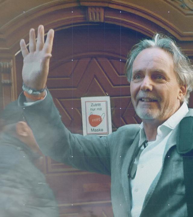 Arzt Ronald Weikl winkt vor dem Gericht seinen Anhängern zu