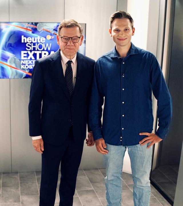 Fabian Köster und Johann Wadephul stehen im Aufzug und schauen freundlich in die Kamera.