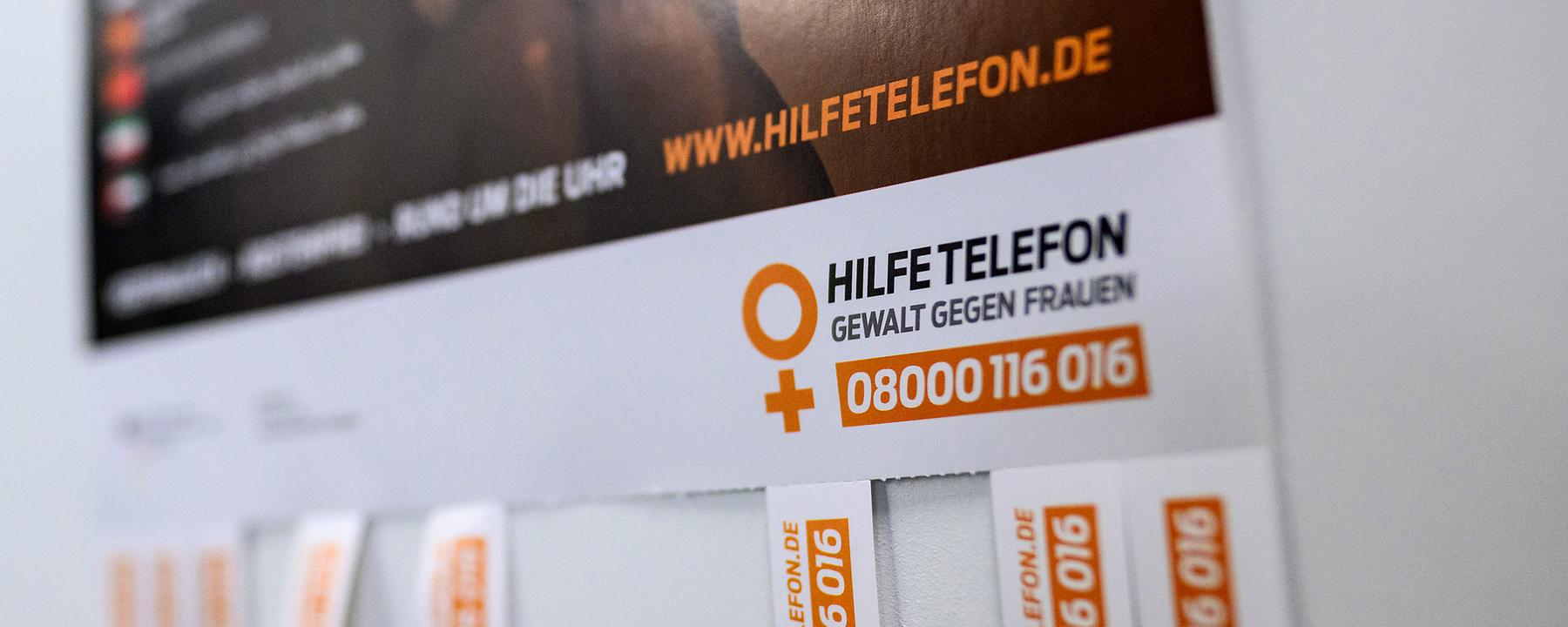 Archiv: Ein Plakat mit Informationen zum Hilfetelefon für Gewalt gegen Frauen hängt an einer Tür