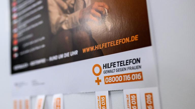 Archiv: Ein Plakat mit Informationen zum Hilfetelefon für Gewalt gegen Frauen hängt an einer Tür