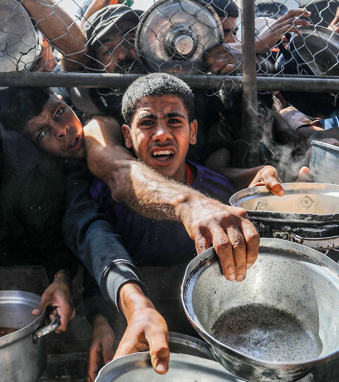 Vertriebene Palästinenser, darunter Frauen und Kinder, die in Zelten leben, erhalten am 30. Mai 2025 von Hilfsorganisationen im Bezirk al Mawasi in Khan Yunis, Gaza, verteilte Nahrungsmittel.