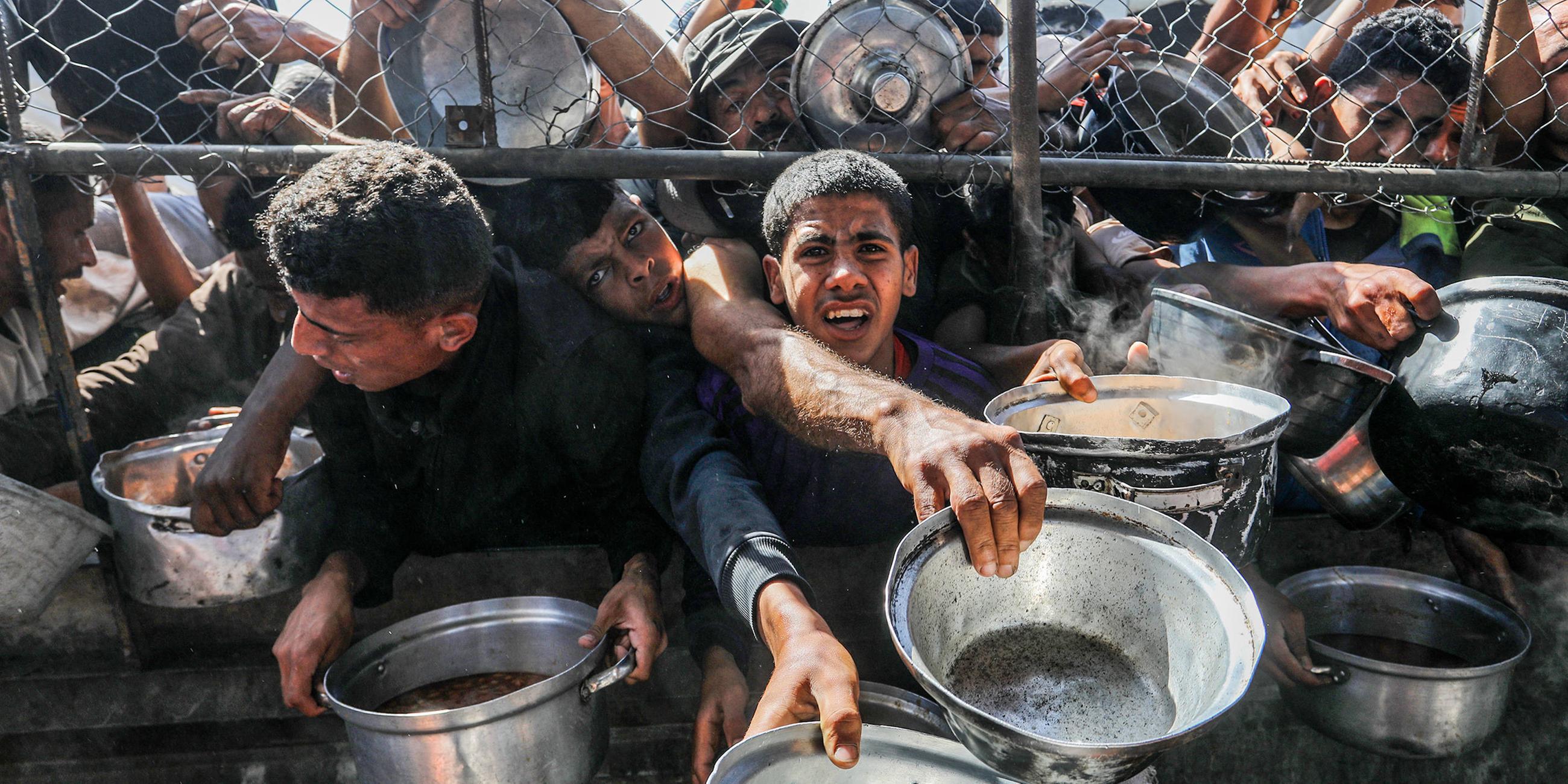 Vertriebene Palästinenser, darunter Frauen und Kinder, die in Zelten leben, erhalten am 30. Mai 2025 von Hilfsorganisationen im Bezirk al Mawasi in Khan Yunis, Gaza, verteilte Nahrungsmittel.
