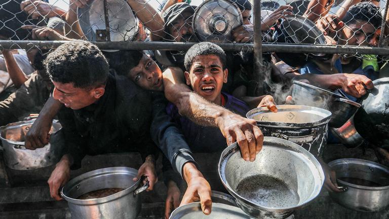 Vertriebene Palästinenser, darunter Frauen und Kinder, die in Zelten leben, erhalten am 30. Mai 2025 von Hilfsorganisationen im Bezirk al Mawasi in Khan Yunis, Gaza, verteilte Nahrungsmittel.