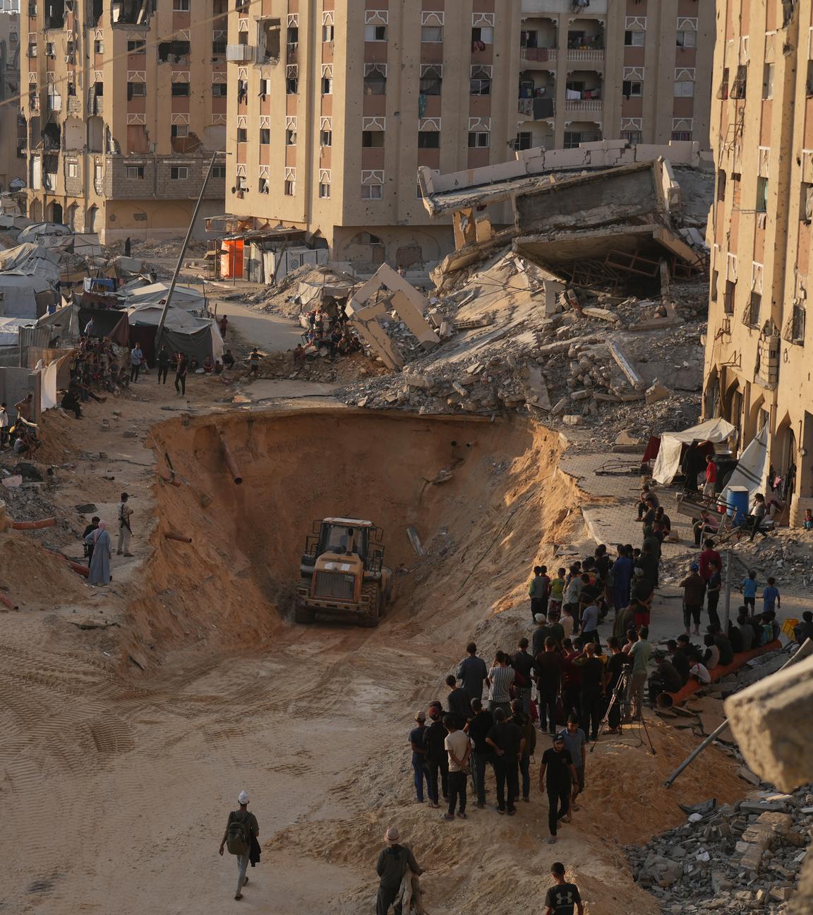 alästinensische Gebiete, Chan Junis: Palästinenser beobachten Mitglieder der militanten Hamas bei der Suche nach Leichen von Geiseln mit schwerem Gerät im Gebiet von Hamad-Stadt im südlichen Gazastreifen.
