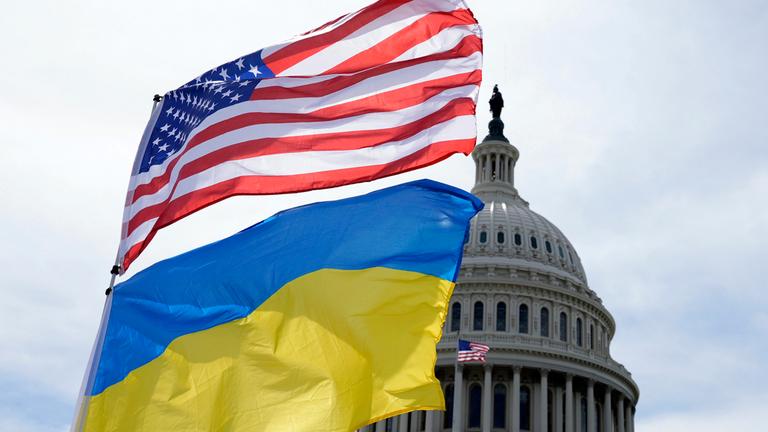  USA, Washington: Die US-amerikanische und die ukrainische Flagge wehen vor dem Kapitol in Washington im Wind.