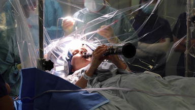 Eine Frau spielt während einer Operation auf einer Klarinette.