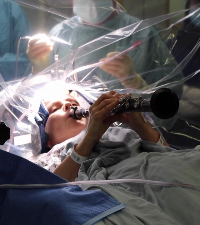 Eine Frau spielt während einer Operation auf einer Klarinette.