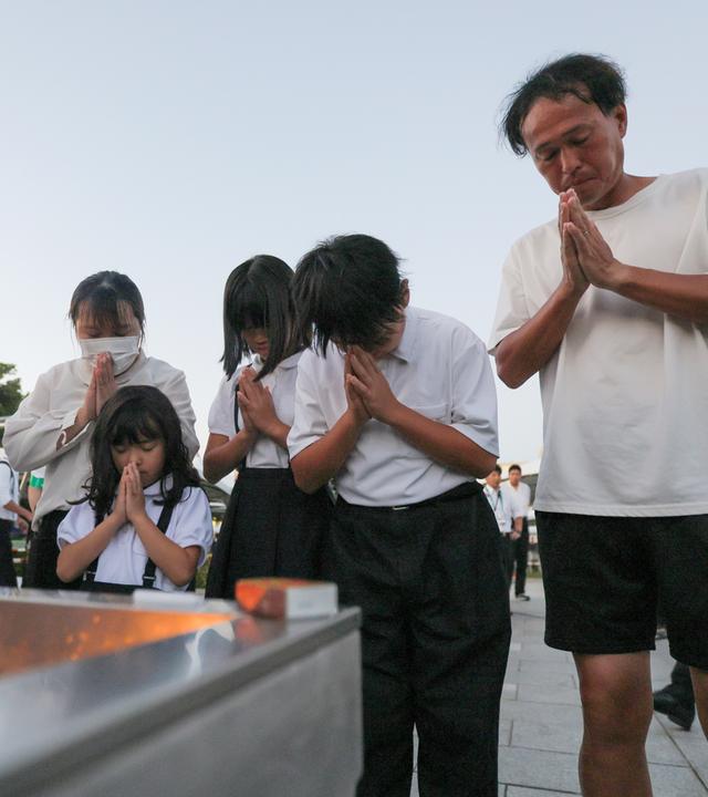 Menschen beten für die Opfer im Friedenspark von Hiroshima (Japan) im Vorfeld der Friedensgedenkfeier anlässlich des 81. Jahrestags des Atombombenabwurfs auf Hiroshima am 6. August 2026.