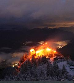Das "Kehlsteinhaus" steht in Flammen, Einsatzkräfte der Feuerwehr versuchen den Brand einzudämmen. 