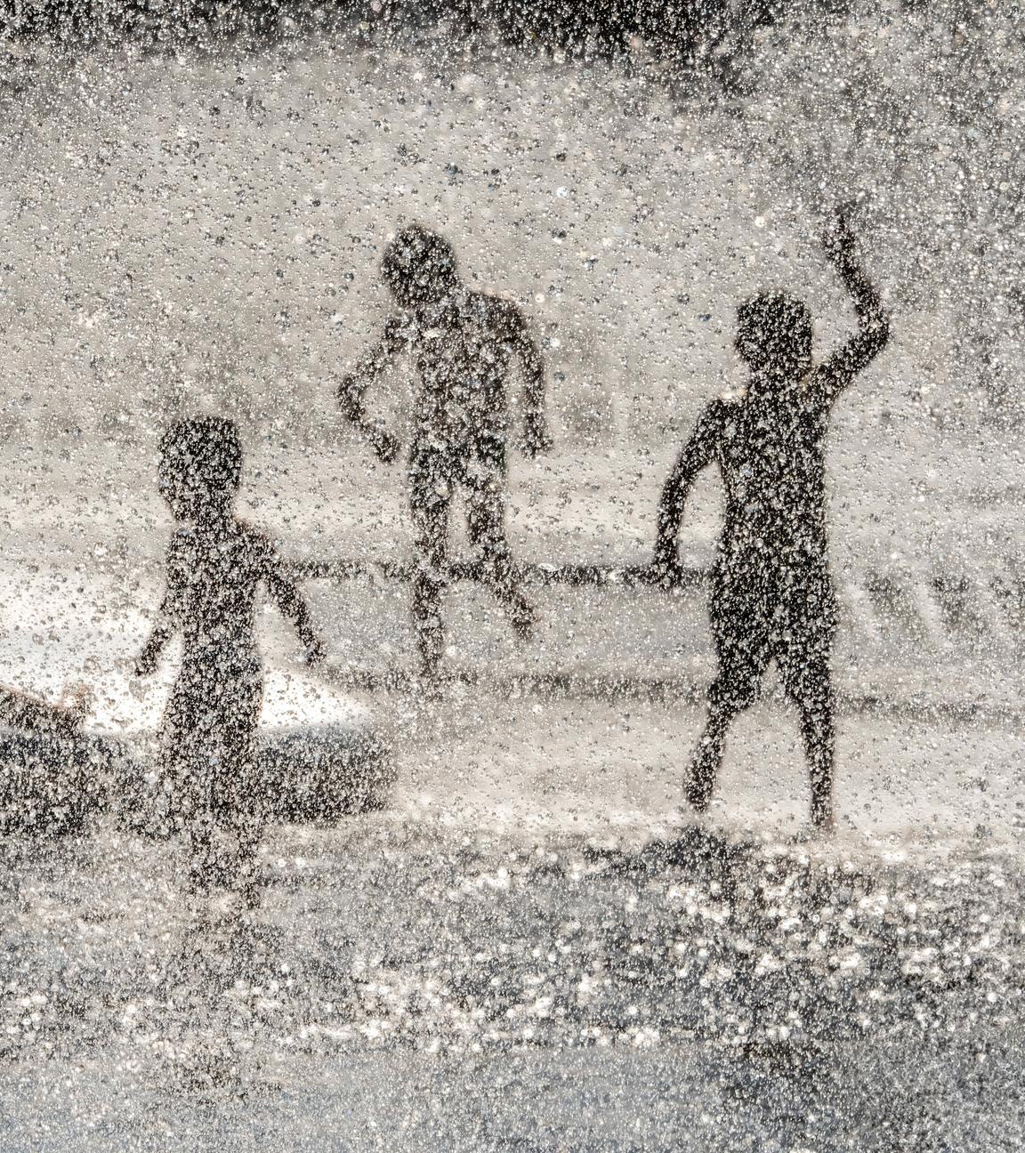 Kinder laufen durch die Wasserfontänen des Stachusbrunnens, Karlsplatz, München, August 2024.
