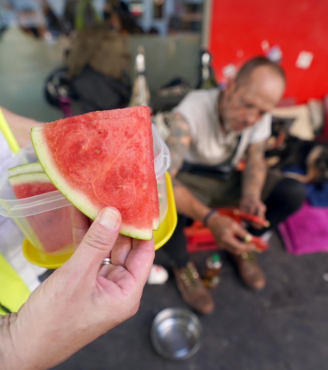 Christina Pillat-Prieß, Koordinatorin Kältebus, verteilt auf der Reeperbahn auf St. Pauli Stücke von Wassermelonen an Obdachlose. 