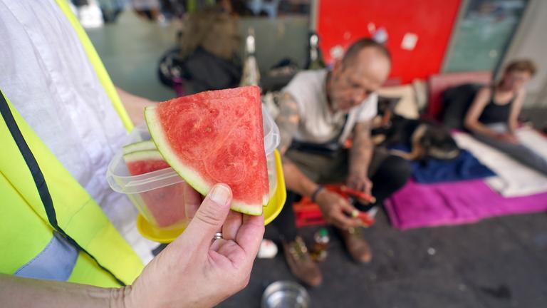 Christina Pillat-Prieß, Koordinatorin Kältebus, verteilt auf der Reeperbahn auf St. Pauli Stücke von Wassermelonen an Obdachlose. 