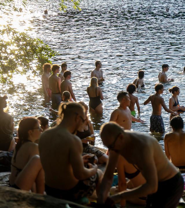 Menschen erfrischen sich abends in der Krummen Lanke in Berlin. (Archiv)