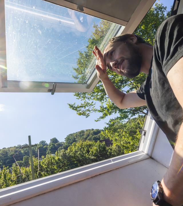Chemie- und Informatikstudent Johannes Wichert schaut aus dem Dachfenster der WG-Küche im Dachgeschoss.