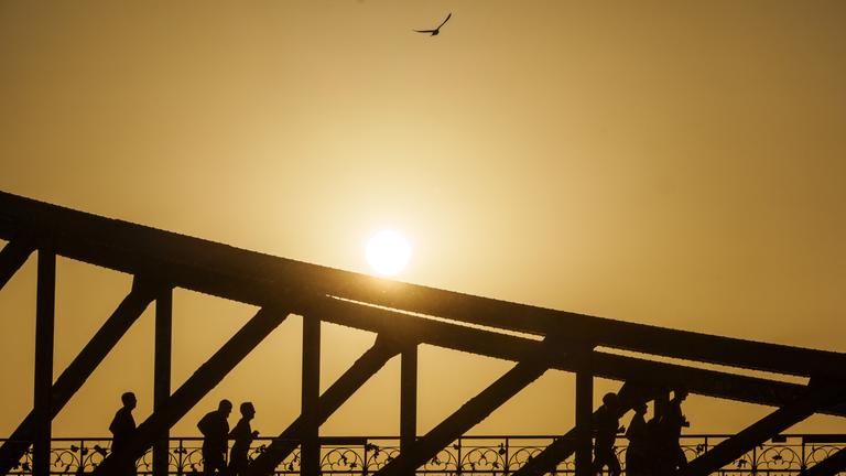  Eine Gruppe joggt bei Sonnenaufgang über den Eisernen Steg.