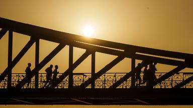 Eine Gruppe joggt bei Sonnenaufgang über den Eisernen Steg