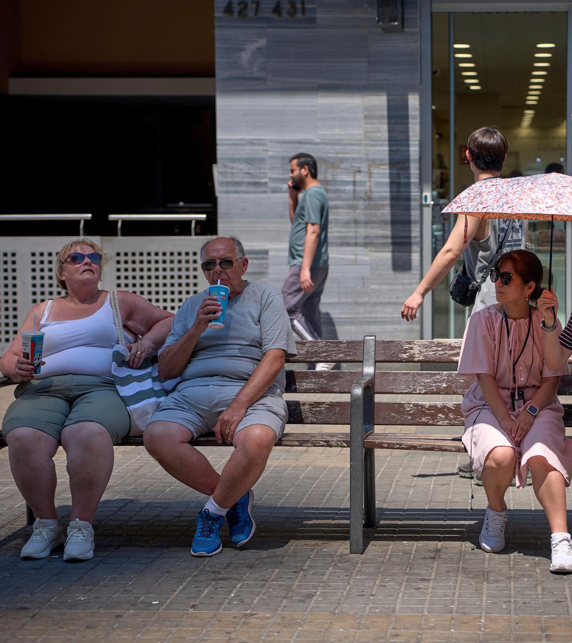 Ein Paar schützt sich an einem heißen Tag in Barcelona, ​​Spanien, am Montag, den 30. Juni 2025, mit einem Regenschirm vor der Sonne.