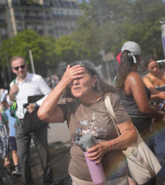 Frankreich, Paris: Touristen erfrischen sich an einem öffentlichen Trinkbrunnen in Paris