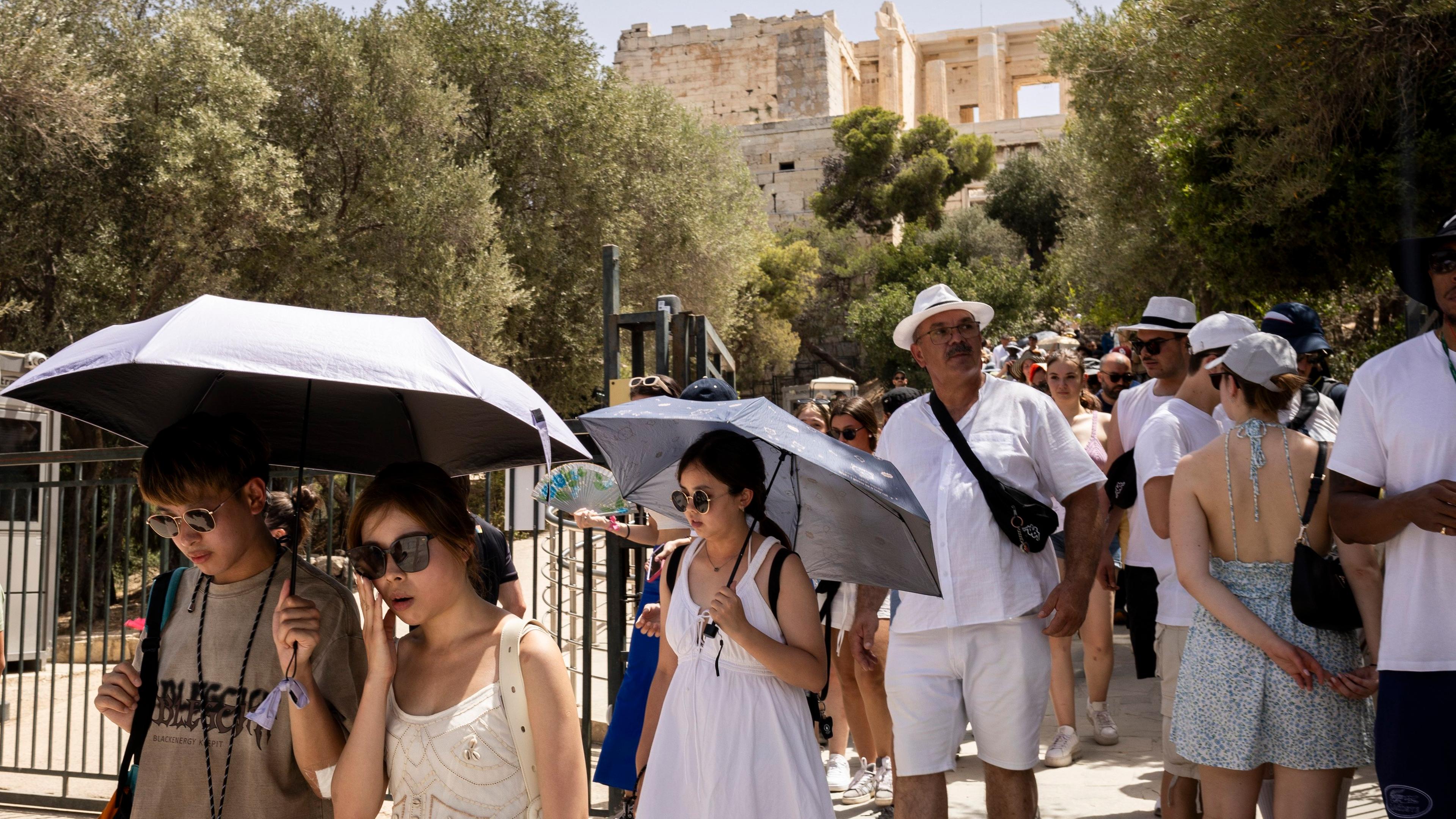 Touristen verlassen die Akropolis, die von 12:00 bis 17:00 Uhr wegen der Hitze geschlossen ist.